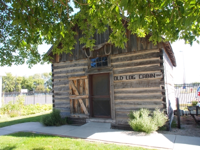 [Well-chinked log cabin with a sloped roof creating a quasi-second level to the cbain.]